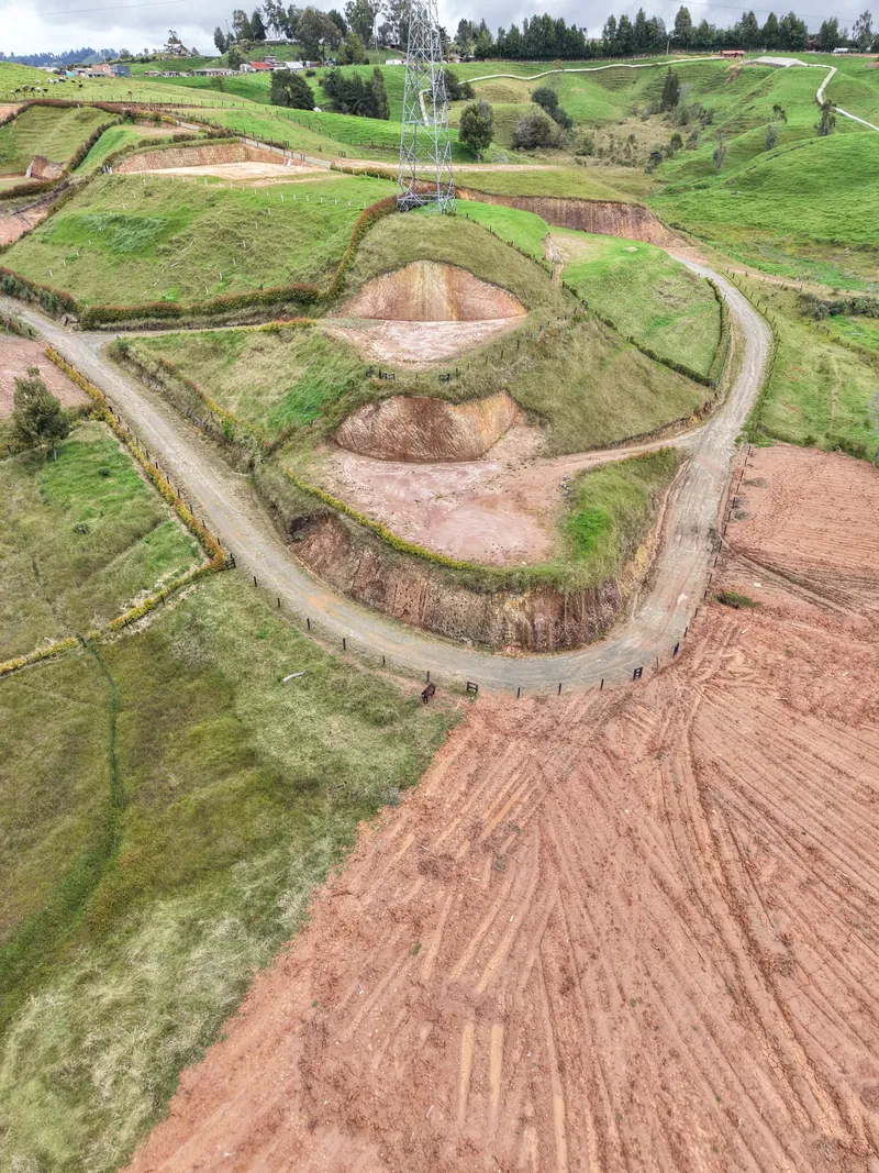 Terrazas del loteo con la vía en curva y las montañas de Santa Rosa de Osos al fondo